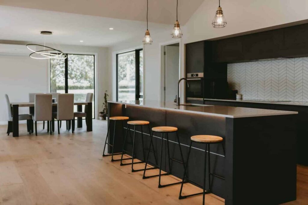 Open-plan kitchen and dining area with light timber-look flooring in a contemporary home.